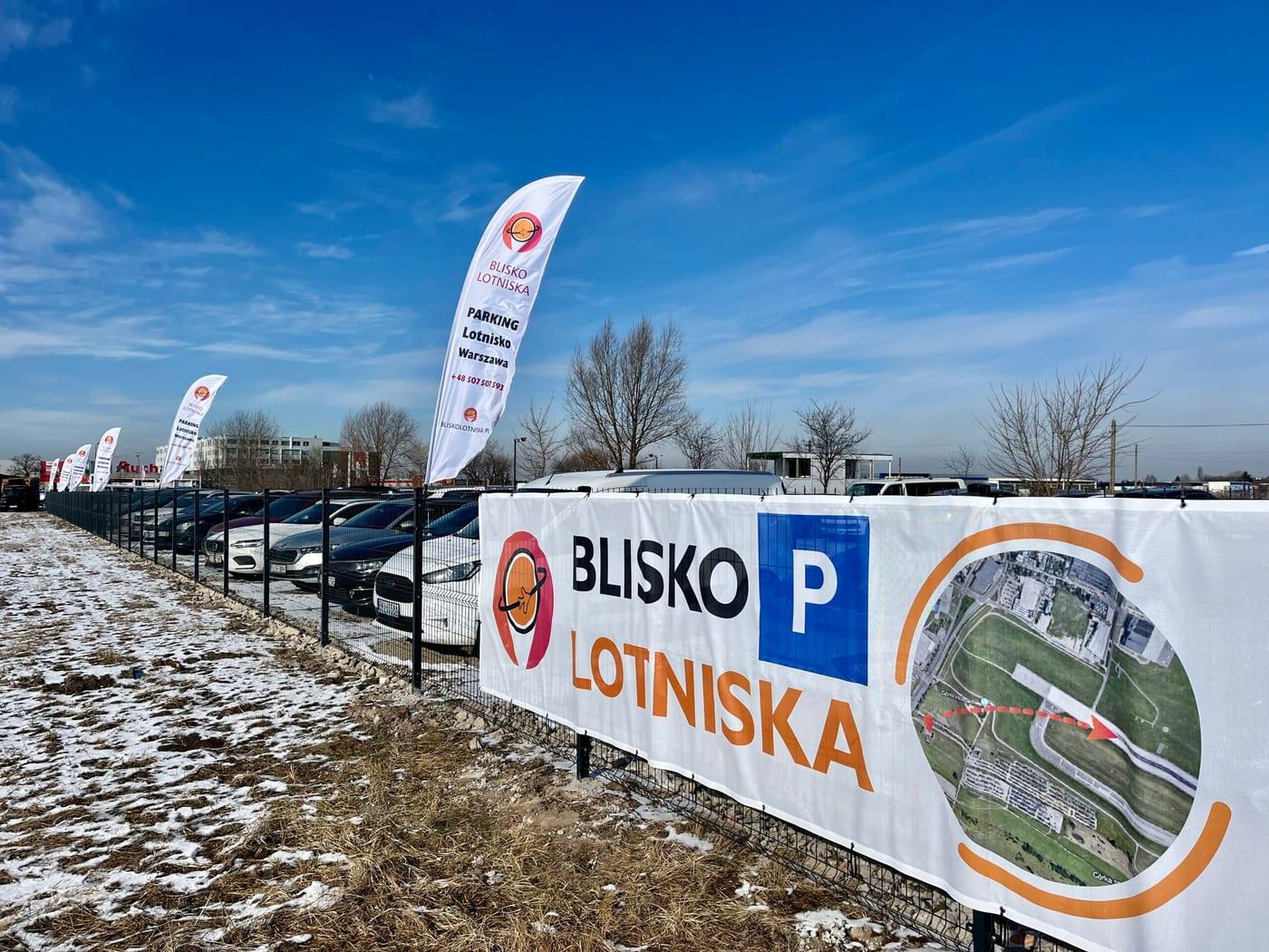 Fenced Bliskolotniska car park with flags near Chopin Airport