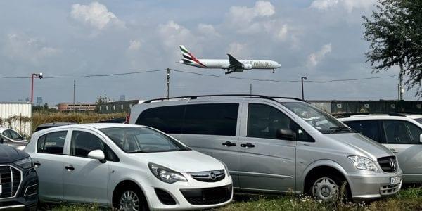 Cars in the car park and a plane above Chopin Airport